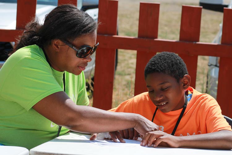 A volunteer assists a young man in Life Camp.